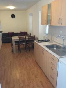 eine Küche und ein Wohnzimmer mit einem Sofa und einem Tisch in der Unterkunft Apartment Kova - 10 m from sea in Murter