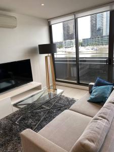 a living room with a couch and a glass table at Wyndel Apartments MEL81306s in Melbourne