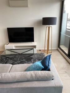 a living room with a couch and a tv at Wyndel Apartments MEL81306s in Melbourne +2 photos