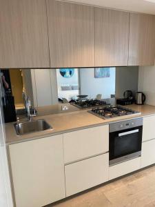 a kitchen with a sink and a stove at Wyndel Apartments MEL81306s in Melbourne