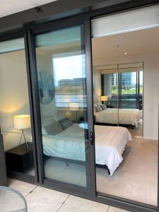 a room with two beds and glass doors with a bedroom at Wyndel Apartments MEL81306s in Melbourne
