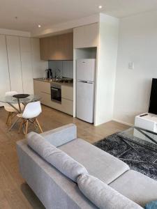 a living room with a couch and a kitchen at Wyndel Apartments MEL81306s in Melbourne