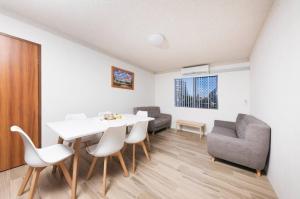 uma sala de estar com uma mesa e cadeiras brancas em Breakers 3 - linen not included em Forster
