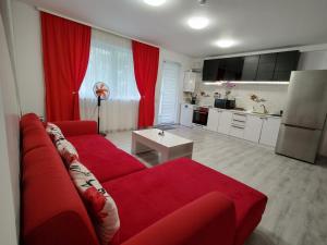 sala de estar con sofá rojo y cocina en Apartament cu terasa Atelierul de Pizza Floresti Cluj, en Floreşti