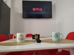 dos tazas de café sentadas en una mesa con TV en Apartament cu terasa Atelierul de Pizza Floresti Cluj, en Floreşti