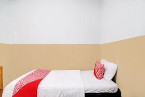 プカンバルにあるOYO 92933 Marvel House Syariahのベッド(赤と白の枕2つ付)