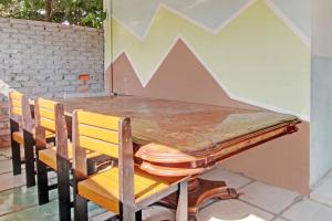 プカンバルにあるOYO 92933 Marvel House Syariahの木製テーブル(椅子2脚付)