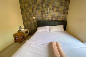 - une chambre avec un lit et des serviettes dans l'établissement OYO 92932 Guesthouse Marbella, à Nongsa