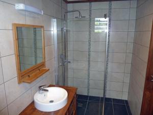 uma casa de banho com um lavatório e um chuveiro em bambous-bungalows em Entre-Deux