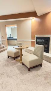 ein Wohnzimmer mit einem Tisch, Stühlen und einem Kamin in der Unterkunft Inn of the Dove - Romantic Luxury Suites with Jacuzzi & Fireplace at Harrisburg-Hershey-Philadelphia, PA in Harrisburg