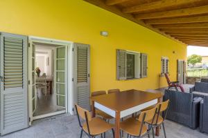 un tavolo e sedie su un patio con parete gialla di Casa Veligato 2 - Happy Rentals a San Siro