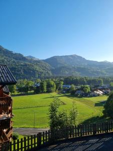 a view of a field and mountains from a house at Studio du lac bleu in Morillon