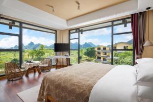 a bedroom with a large bed and large windows at Guilin Village Creek Inn--Fee pick up service over three nights in Guilin +125 photos