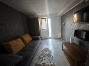 - un salon avec un canapé et une télévision dans l'établissement În Buna Ziua, à Cluj-Napoca