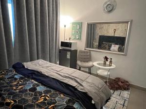 - une chambre avec un lit, une table et une chaise dans l'établissement Park view bedroom in family apartment, à Charjah
