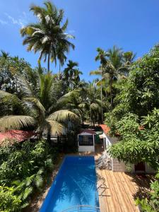 a view of a resort with a swimming pool and palm trees at Sundeck Villa in Alibaug