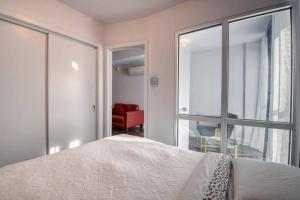 um quarto com uma cama e uma cadeira vermelha em 2 bedroom Condo in the heart of the city Montreal em Montreal