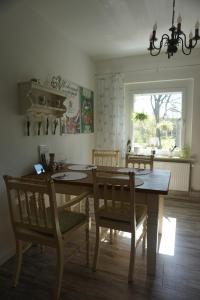 una sala da pranzo con tavolo e sedie in legno di Dat Wittsche Hus - Ferienwohnung an der Nordsee a Wilhelmshaven