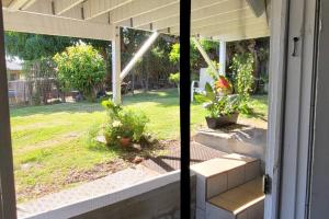 an open door with a view of a yard at Cool, quiet ocean view 30 day min in Honolulu