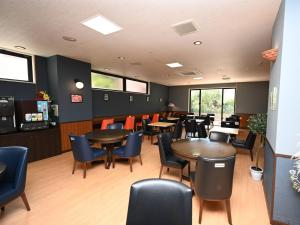 a dining room with tables and chairs and windows at ホテルアビアンパナ石垣島 in Ishigaki Island