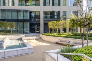 a building with a fountain in front of a building at Urban Rest Canary Wharf Apartments in London