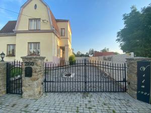 une porte en fer noir devant une maison dans l'établissement Vila 1921, à Jevišovice