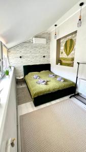 een slaapkamer met een groen bed in een kamer bij Чудові апартаменти «D.I.M.» в Старому місті in Kamjanets-Podilsky