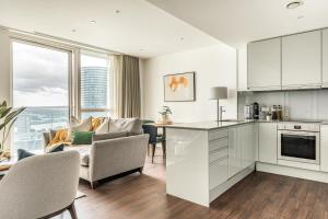 a kitchen and living room with a table and chairs at Urban Rest Canary Wharf Apartments in London