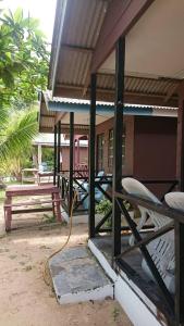 a porch of a house with a table and a bench at Barook Chalet in Mersing