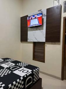 a flat screen tv on a wall in a room at David Guesthouse by XNR in Kemiri