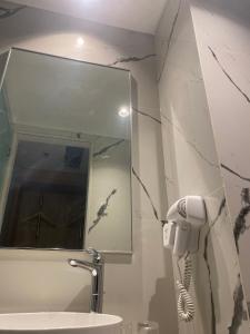 - une salle de bains avec un téléphone sur le mur à côté d'un lavabo dans l'établissement David Guesthouse by XNR, à Kemiri