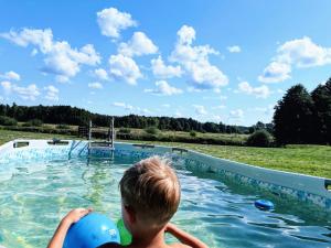 un ragazzo in una piscina con una palla di Marzenie Dziadka - siedlisko obok Augustowa 