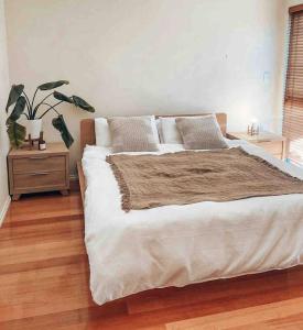 Un dormitorio con una cama grande y una maceta en Sunset views over South Fremantle en Fremantle