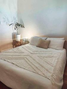 a white bed with two pillows on top of it at Sunset views over South Fremantle in Fremantle