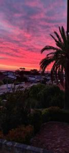 una puesta de sol con una palmera en un estacionamiento en Sunset views over South Fremantle en Fremantle