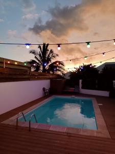 a swimming pool in a backyard with christmas lights at Les bungalows du chateau d'Ô in Petite Île