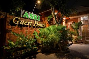 a guest house with plants in front of it at night at Asri Guesthouse in Canggu