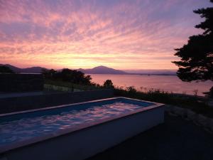 una piscina con puesta de sol en el fondo en Vesper Namhae en Namhae