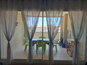 - une table et des chaises dans une chambre avec fenêtre dans l'établissement Appartement Résidence Les Eucalyptus, à LʼÎle-Rousse