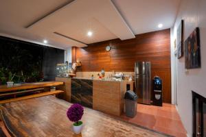 a kitchen with a table and a stainless steel refrigerator at Asri Guesthouse in Canggu