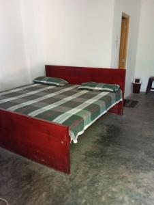 uma cama de madeira com lençóis com riscas verdes e brancas em Green berg 