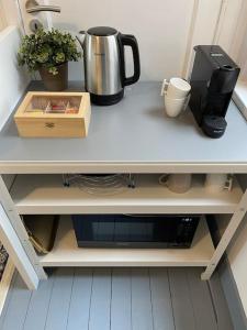 a counter top with a coffee pot and a box at Cosy renovated 1 bedroom apartment. in Antwerp