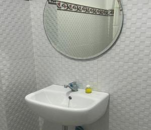 y baño con lavabo blanco y espejo. en Villa Jagung, en Mantang