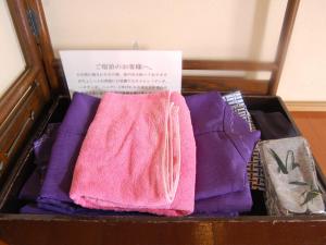 una caja llena de toallas púrpuras y moradas en Oyado Yunosato en Shirakawa