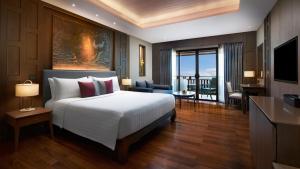 a bedroom with a large bed and a living room at Amari Vogue Krabi in Tab Kaek Beach
