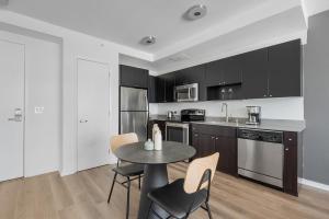 a kitchen with black cabinets and a table and chairs at SoMa 1br w roofdeck gym pet area nr groceries SFO-1430 in San Francisco