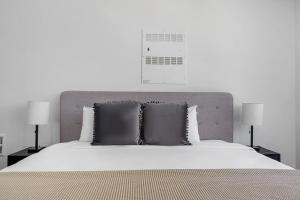 a white bed with two pillows on top of it at SoMa 1br w roofdeck gym pet area nr groceries SFO-1430 in San Francisco