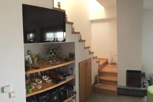 un salon avec une télévision et un escalier dans l'établissement Irene Appartment, à Katakolon