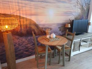 a dining room with a table and a tv at 't Hoekhuisje in Katwijk aan Zee
