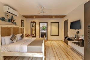 a bedroom with a large bed and a flat screen tv at Skon Morjim Beach Resort by Orion Hotels in Morjim
